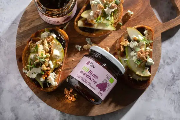 Krem balsamiczny Olini na grzankach z gruszką, serem i orzechami. Różnica między octem balsamicznym a kremem balsamicznym w dekoracji jest widoczna w gęstości i sposobie aplikacji.
