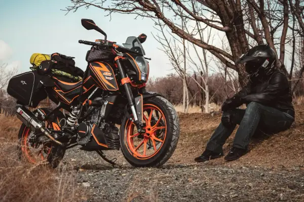 Pomarańczowy motocykl KTM z sakwami, gotowy na przygodę. Idealny sprzęt na pierwsze enduro.