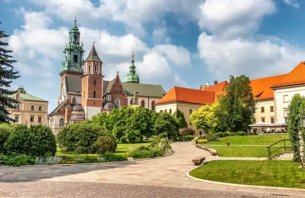 Wawel cennik: malowniczy widok na zamek i katedrę z zielonymi ogrodami i brukowanymi alejkami.