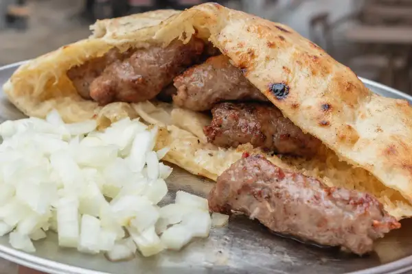 Pyszne cevapcici w bułce, jak u Makłowicza, z dużą ilością cebulki.
