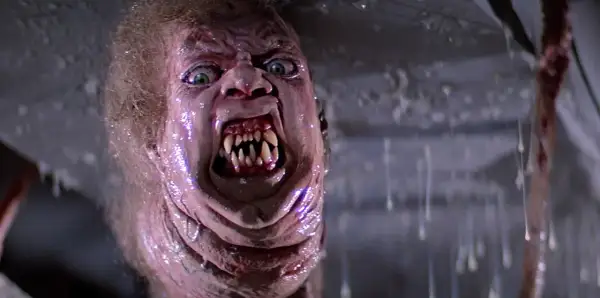 Potwór z klasycznych **filmy sci-fi lata 80.** z przerażającymi zębami i zielonymi oczami, w mokrym, obrzydliwym otoczeniu.