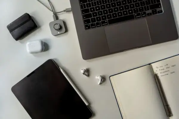 Staż pracy umowa zlecenie: laptop, tablet, słuchawki i notatnik z listą zadań.