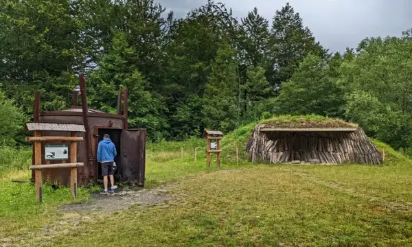 W muzeum wypału węgla drzewnego zwiedzający ogląda zabytkowy piec. Obok znajduje się kopułowa wiata z drewnem.