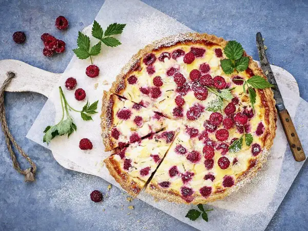 En härlig hallonpaj, perfekt för ett somrigt hallonpaj recept. Garnerad med färska hallon och myntablad.
