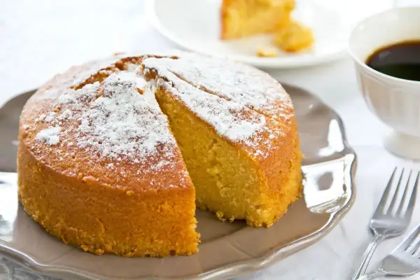 Una deliziosa torta senza glutine, spolverata di zucchero a velo, pronta per essere gustata con un caffè.