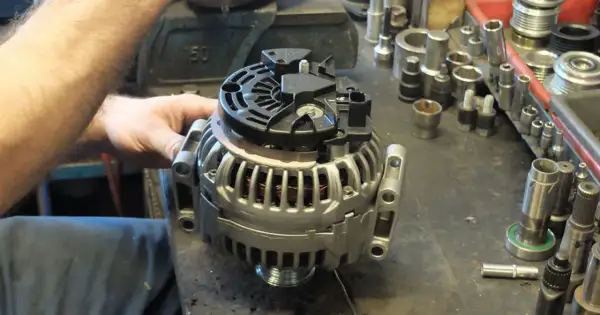 Warsztat samochodowy, gdzie mechanik sprawdza alternator. Dowiedz się, ile kosztuje regeneracja alternatora i jakie części są potrzebne.
