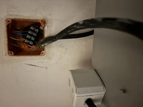 Instalacja elektryczna: jak podłączyć piekarnik bez wtyczki. Widoczne przewody w puszce instalacyjnej i gniazdko.