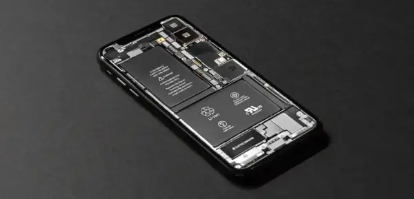 Rozłożony iPhone SE z widoczną baterią i podzespołami.