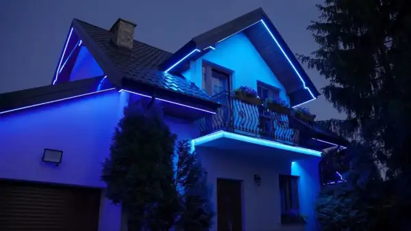Dom oświetlony niebieską listwą RGB, podkreślającą jego architekturę.