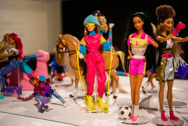 Wystawa muzeum sztuk użytkowych Barbie: lalki w strojach narciarskich, sportowych i jeździeckich, z koniem i piłką.