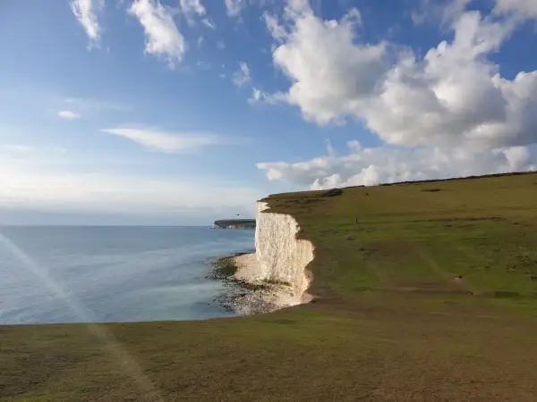 Majestatyczne białe klify w Sussex, morze i błękitne niebo z chmurami.
