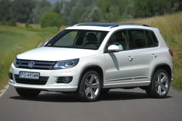 Biały Volkswagen Tiguan na drodze. Sprawdź jego wymiary i możliwości terenowe.