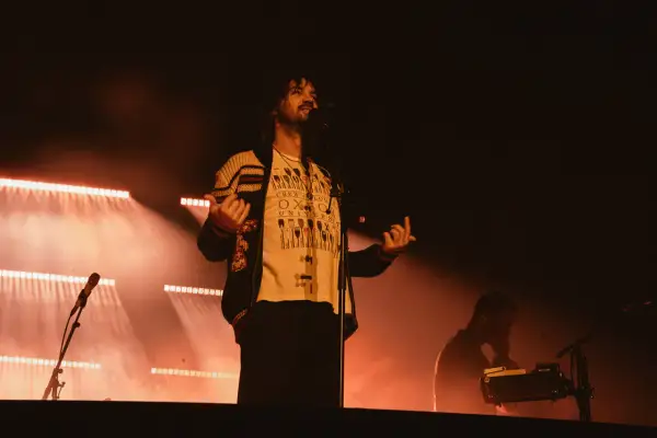 Kevin Parker z Tame Impala na koncercie w Gliwicach, w świetle reflektorów.