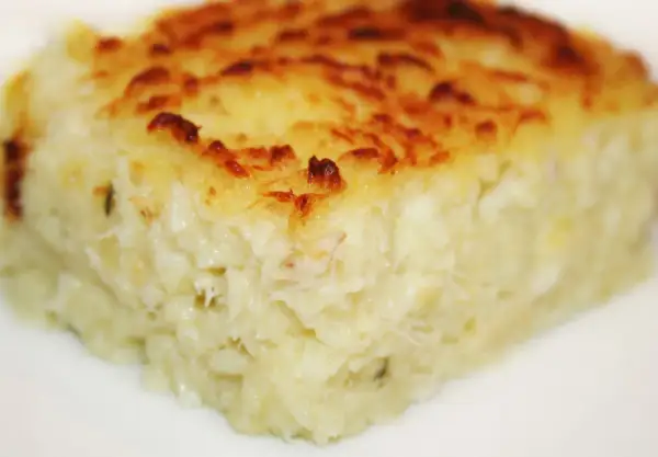 Un morceau de brandade de poisson gratinée, prêt à être dégusté. Une recette savoureuse et réconfortante.