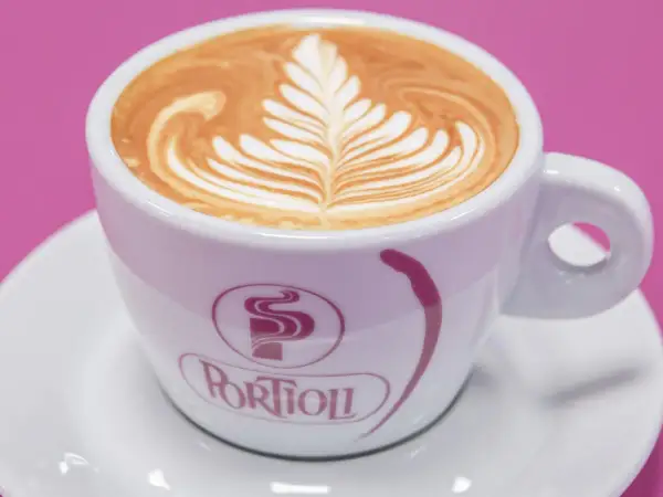 Un cappuccino con latte art a forma di foglia, uno dei tanti tipi di cappuccino che deliziano gli occhi e il palato.