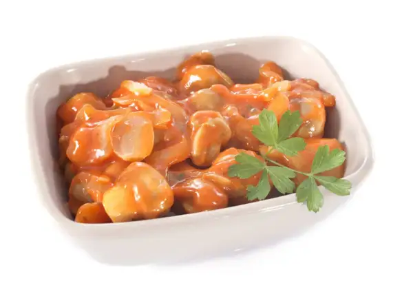 Un plat de champignons à la grecque, tendres et savoureux, baignant dans une sauce tomate onctueuse, garni d'une touche de persil frais.