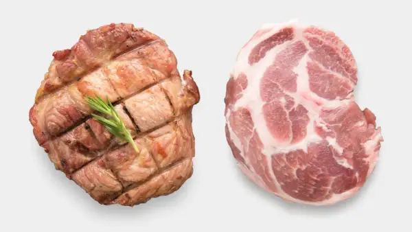 Zwei Schweinefleischstücke: eines roh mit Marmorierung, das andere gegrillt mit Rosmarin. Ist Schweinefleisch ungesund?