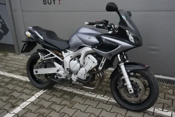 Szary motocykl Yamaha FZ6 z czarnymi akcentami, gotowy do jazdy po miejskich ulicach.