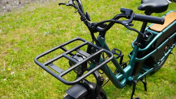 Zielony rower elektryczny dla seniora z dużą platformą bagażową z przodu i wygodnym siodełkiem. Idealny na zakupy i wycieczki.