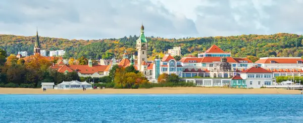 Sopot co warto zobaczyć: malowniczy widok na plażę, morze i zabytkowe budynki z charakterystyczną wieżą.