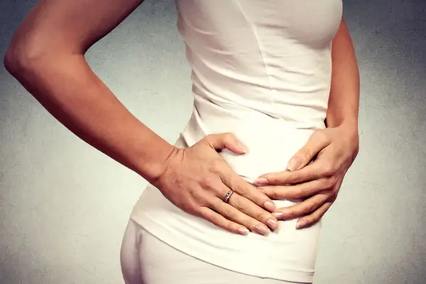 Donna con le mani sull'anca, che esprime dolore anca e ginocchio a riposo.