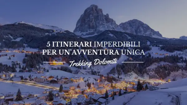 Paesaggio invernale con villaggio illuminato e montagne innevate. 5 itinerari imperdibili per un'avventura unica: Trekking Dolomiti.