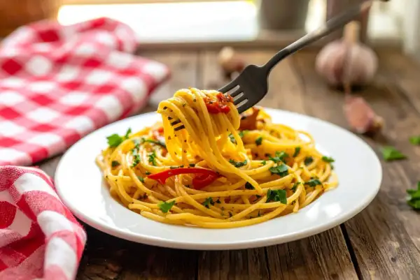 Un piatto di spaghetti alla carrettiera fumante, conditi con pomodoro e prezzemolo, pronti per essere gustati.