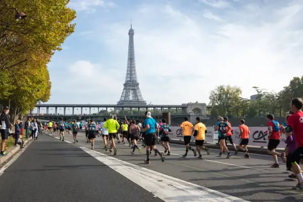 Course de marathon à Paris, avec la Tour Eiffel en arrière-plan. L'allure marathon 3h20 est visée par ces coureurs déterminés.