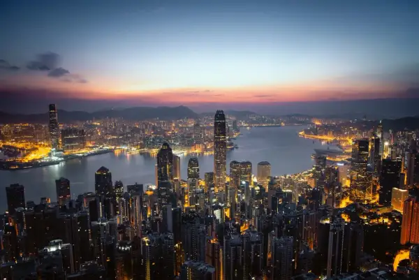 Wieczorny widok na rozświetlony Hongkong. Wiele wieżowców lśni światłami, tworząc niesamowity krajobraz. Ciekawe fakty o tym mieście można odkrywać, podziwiając jego panoramę.