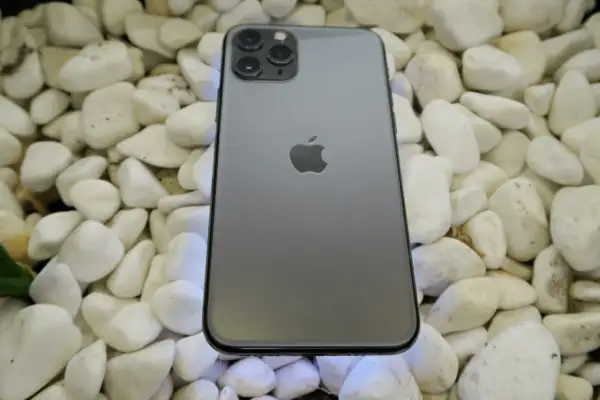 Szary iPhone 11 Pro leży na białych kamieniach. To urządzenie iPhone niedostępne, ale wciąż piękne.