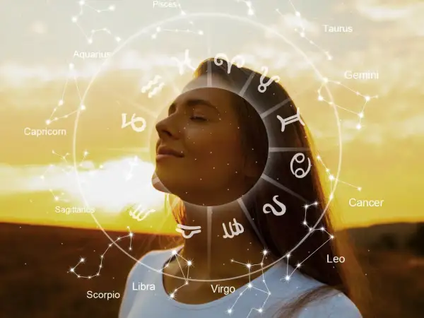 Una mujer con los ojos cerrados, rodeada por el zodíaco y constelaciones, como un ser de luz en armonía con el universo.