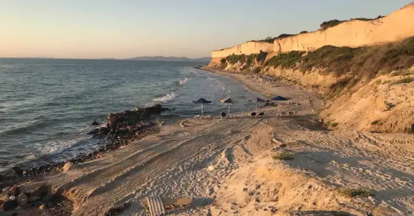 Plaża z klifem w tle, morze i leżaki. Czy warto tu przyjechać? Zdecydowanie tak!