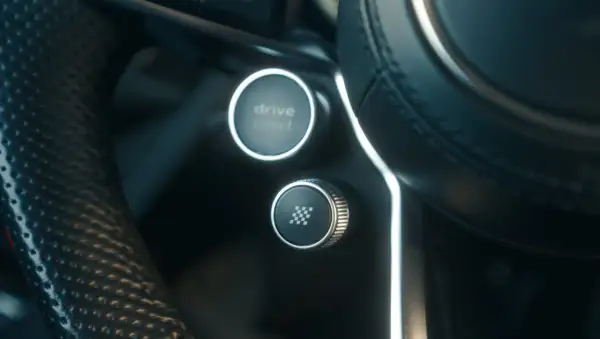 Przycisk "drive select" i przycisk z szachownicą, gotowe do aktywacji launch control.