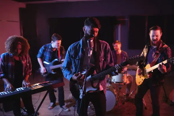 Zespół rockowy grający na gitarach, klawiszach i perkusji w studiu nagraniowym.