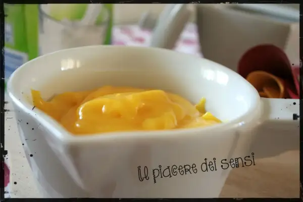 Crema pasticcera ricetta della nonna, densa e dorata, in una ciotola bianca. Un piacere per gli occhi e per il palato.