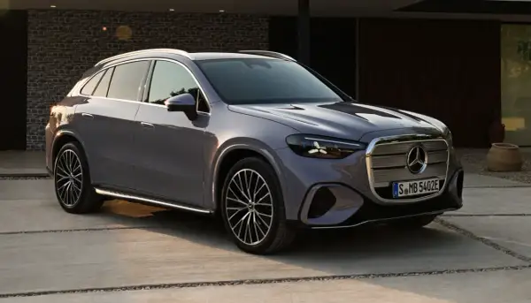Un elegante GLC eléctrico 2026 gris metálico, con diseño moderno y llantas deportivas, estacionado en una entrada de concreto.