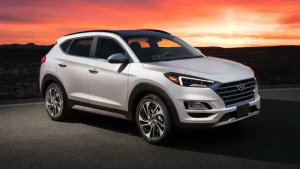 Un Hyundai Tucson blanco con un motor potente, listo para la aventura al atardecer en un paisaje desértico.