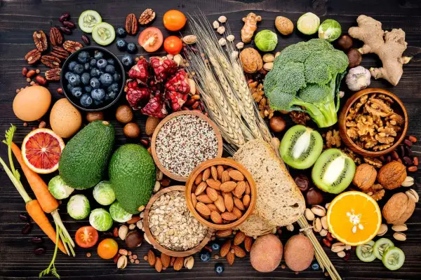 Assortiment de fruits, légumes, noix et céréales, des aliments riches en fibres insolubles pour une alimentation équilibrée.