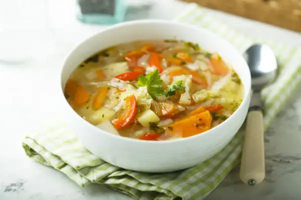 Aromaticzny kapuśniak ze słodkiej kapusty z marchewką i ziemniakami, udekorowany natką pietruszki. Idealny na chłodne dni.