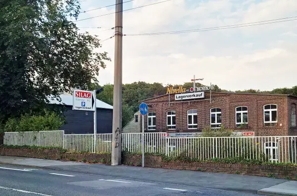 Ziegelgebäude mit Schildern "Nivella-chromolit Lagerverkauf" und "SILAG Handel AG Lagerverkauf" in Piepersberg, Solingen.