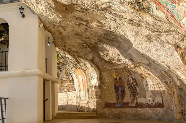 W skalnych niszach monasteru Ostrog widnieją mozaiki świętych. Biała architektura kontrastuje z surową skałą.
