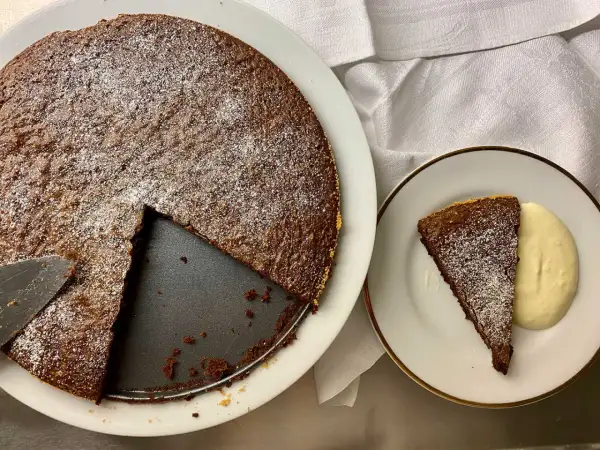 Chokladkaka med pudersocker, en bit serverad med grädde. Perfekt för att baka snabbt och enkelt.