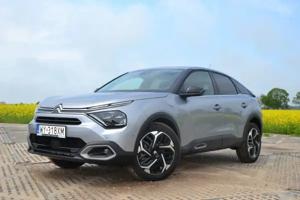Srebrny Citroën C4 na tle kwitnącego pola rzepaku. Stylowy design i nowoczesne linie tego c4 zachwycają.