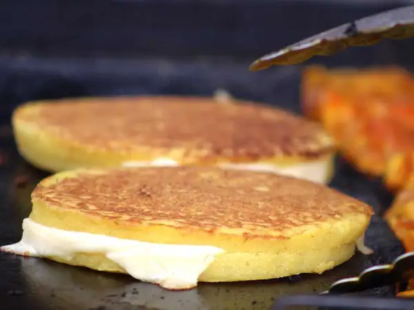 Arepas de choclo doradas y rellenas de queso derretido, listas para ser disfrutadas.