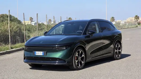 Zeekr 7x, un SUV elettrico dal design futuristico, parcheggiato su strada asfaltata con vegetazione e palme sullo sfondo.