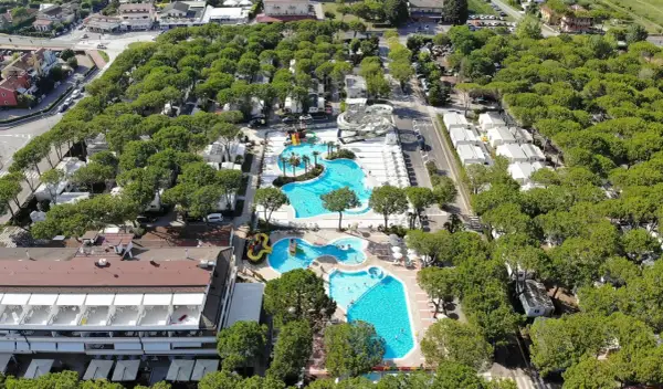 Malowniczy camping residence village z basenami, zjeżdżalniami i domkami wśród drzew. Idealne miejsce na wakacje.