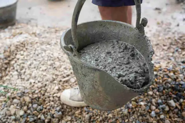 Secchio pieno di cemento fresco, pronto per essere utilizzato. Imparare come fare il cemento è fondamentale per ogni progetto di costruzione.