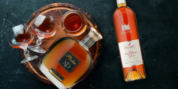 Dwie butelki i kieliszki z brandy, w tym Pliska XO i Frapin Château Fontpinot XO. Dobre brandy do 100 zł.