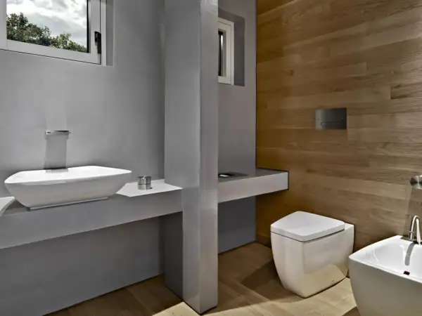 Bagno moderno con lavabo bianco, WC squadrato e pannello di scarico traslato. Problemi di design?