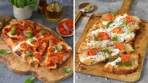 Två pizzor på träskärbrädor. En med pepperoni och basilika, den andra med gräddfil, rödlök, dill och rom. Båda ser ut att ha en härlig pizza sås.